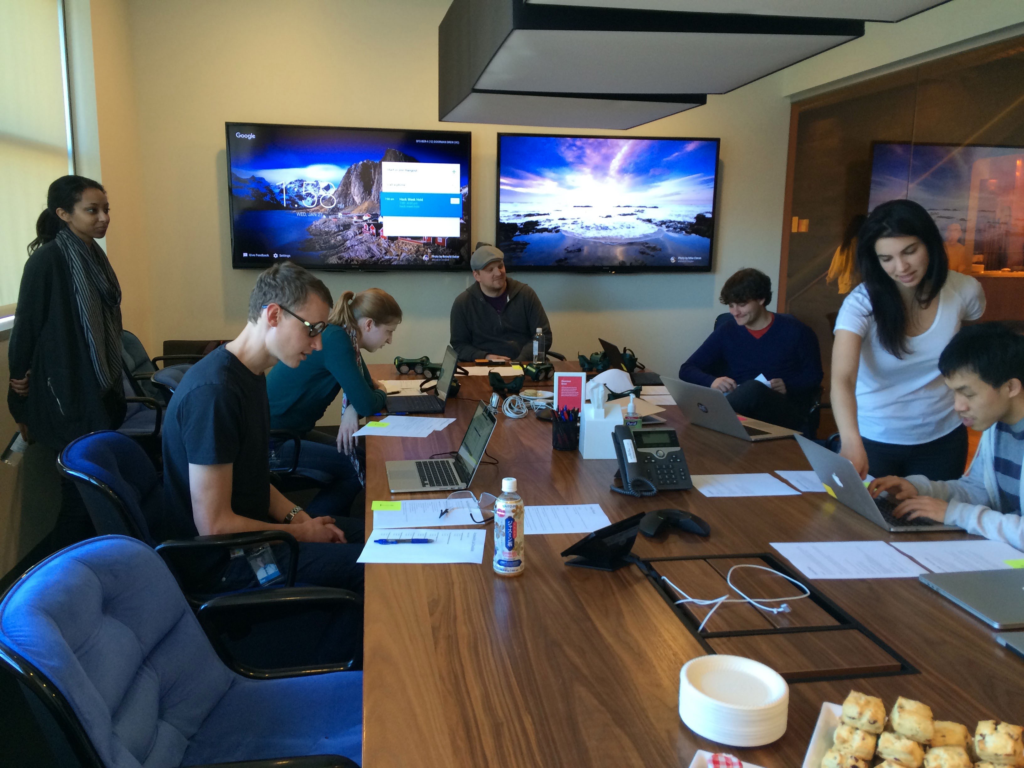 Dropbox employees participating in our Assistive Technology Lab. Here, several people sit around a table with a variety of computers and instruction papers. One is using a head mouse, another a switch control with two buttons.